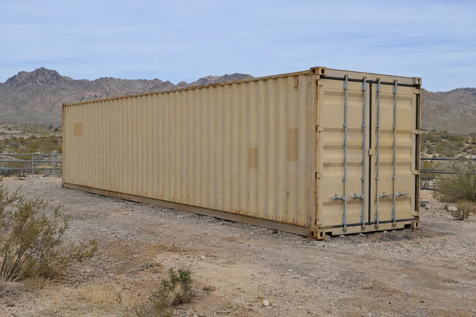 Used tan 40ft container on a gravel pad at a desert ranch outside Arizona