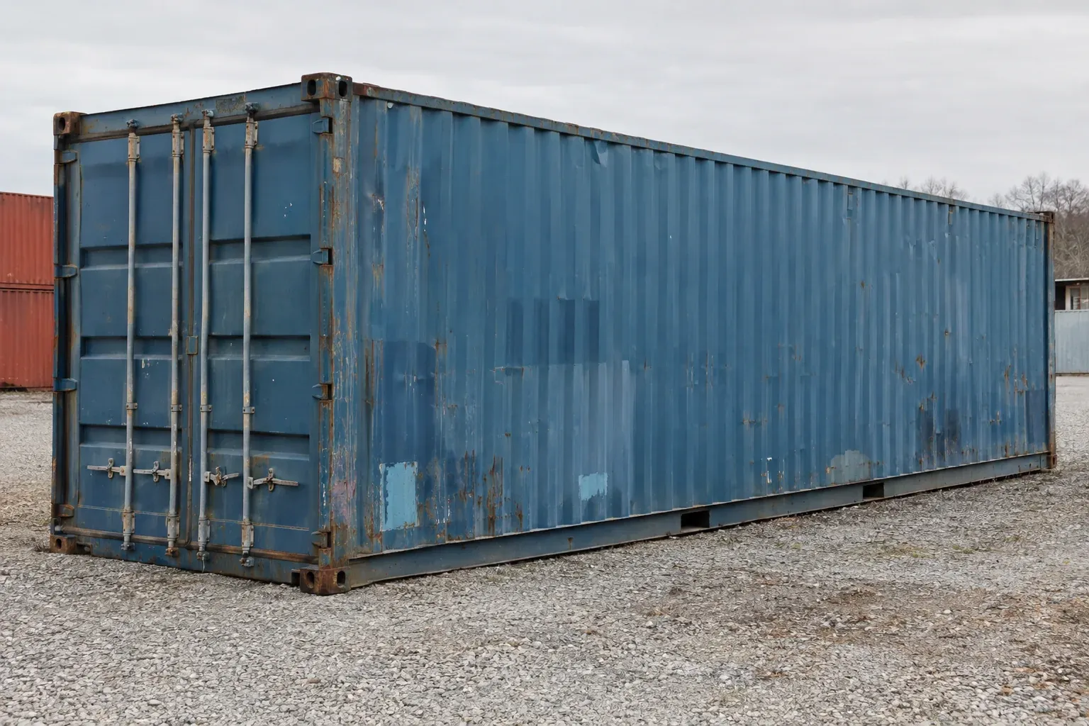 A used blue cargo-worthy container with faded paint, small rust spots and minor dents