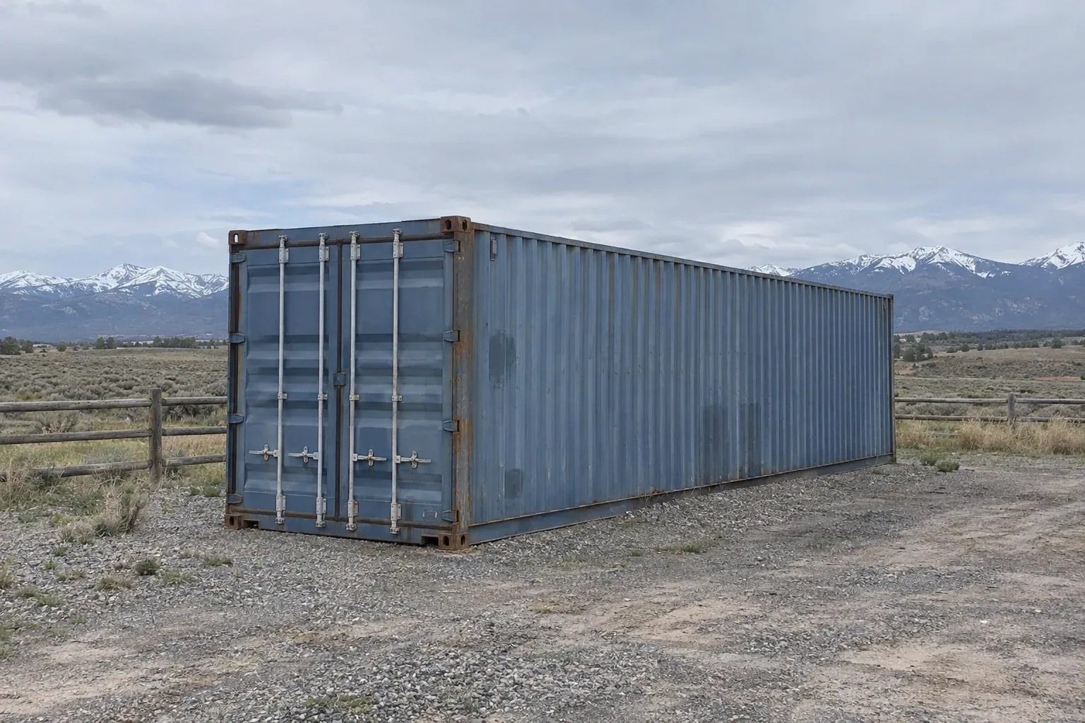 Used blue 40ft container on a ranch below distant mountains outside Montana